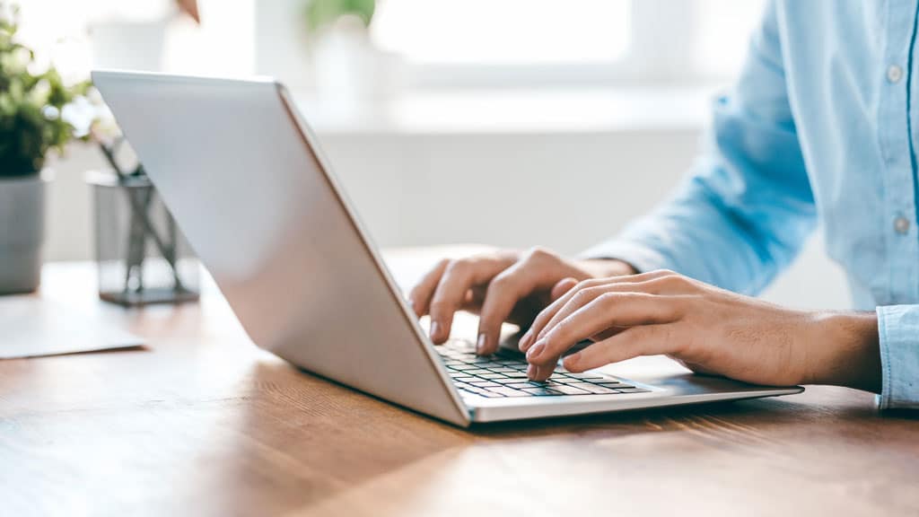 Hands of young contemporary office manager over laptop keypad during work