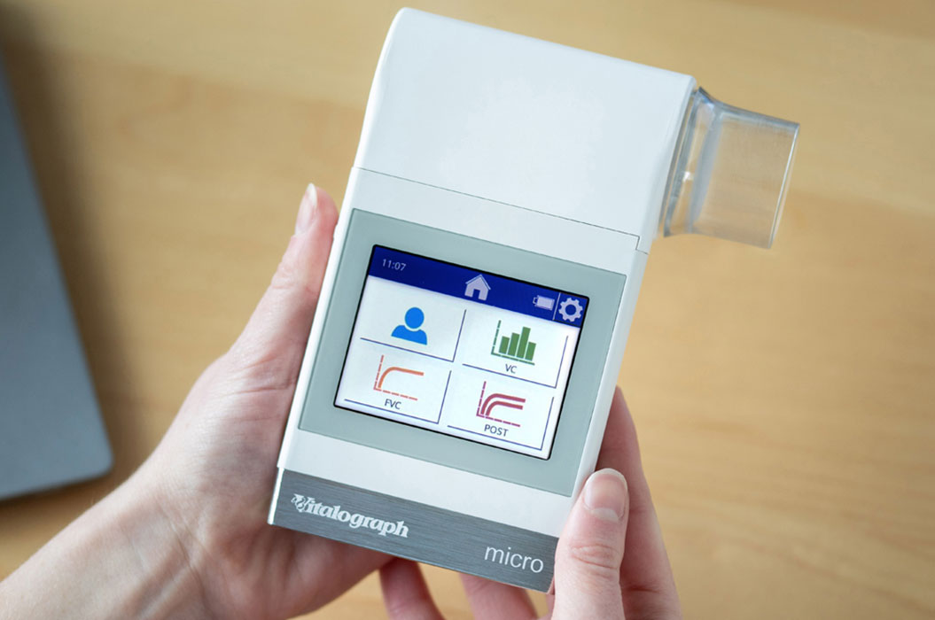 Moderne Atemanalysegerät in Händen, weiß mit Display, zeigt graphische Daten.